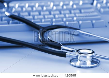 Picture or Photo of A stethoscope by a computer keyboard. computer technology is an integral part of medicine, healthcare, and medical/health insurance today.