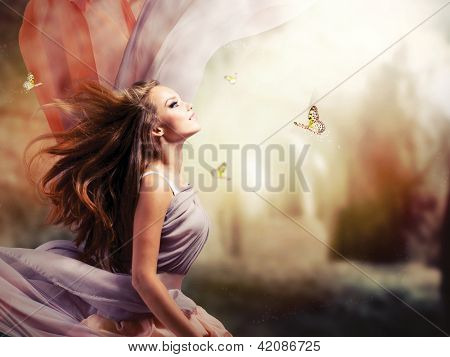 Picture or Photo of Fashion Art Beauty Portrait. Beautiful Girl in Fantasy Mystical and Magical Spring Garden. Model Woman wearing Long Chiffon dress