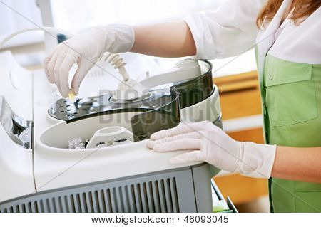 Picture or Photo of Doctor hands in medical gloves with clinical dna chemistry samples near equipment for medical tests