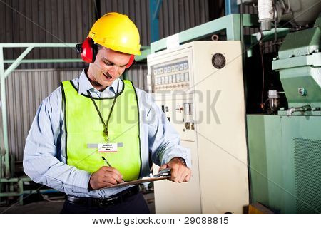 Picture or Photo of Male occupational health and safety officer inside factory doing inspection