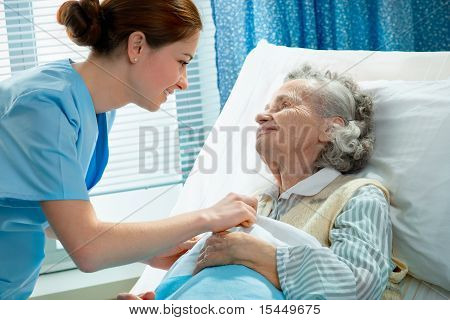 Picture or Photo of Nurse cares for a elderly woman lying in bed