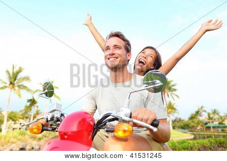 Picture or Photo of Happy free freedom couple driving scooter excited on summer holidays vacation. Young multiethnic couple, Asian woman, Caucasian man