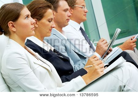 Picture or Photo of Row of business people writing lecture at conference