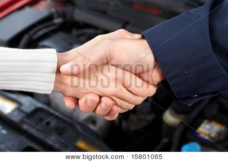 Picture or Photo of Handshake. Mechanic and client woman in auto repair shop.