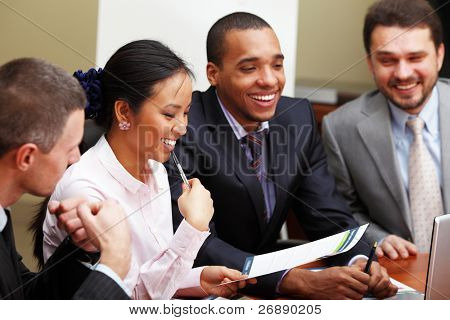 Picture or Photo of Multi ethnic business team at a meeting. Interacting. Focus on woman