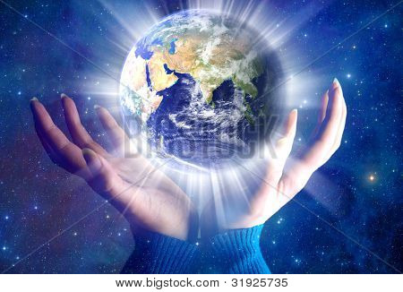 Picture or Photo of Female hands with the planet Earth over starry universe like a concept of new spiritual era, Elements of this image furnished by NASA