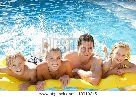 Picture or Photo of Young family having fun together in pool